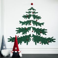 a christmas tree made out of felt sitting next to a gnome's hat on the floor