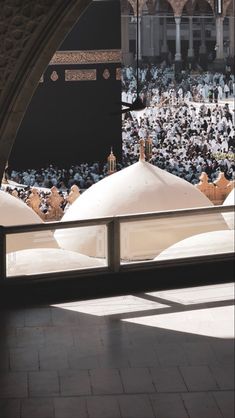 the view from inside an archway into a large group of people