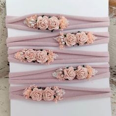 six pink headbands with flowers on them sitting on top of a piece of paper