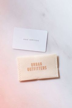 a pair of business cards sitting on top of a white table next to each other