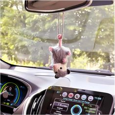 a stuffed animal hanging from the dashboard of a car