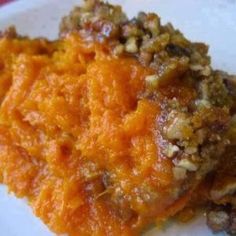 two pieces of food sitting on top of a white plate covered in nuts and orange sauce