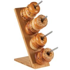 an assortment of donuts are on a wooden stand with skewers sticking out of them