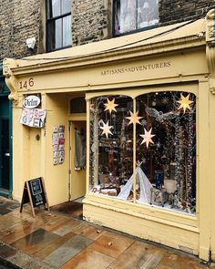 an outside view of a store front with christmas decorations on the windows and stars in the window