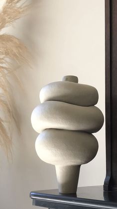 a white sculpture sitting on top of a wooden shelf