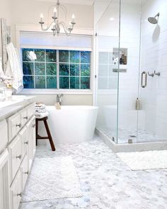 a white bathroom with a tub, sink and shower