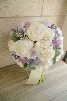 a bridal bouquet with purple and white flowers