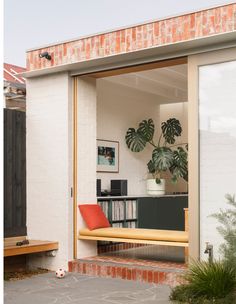 an open patio with a bench and bookshelf