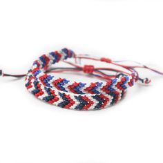 two red, white and blue braided bracelets on a white background with the cord undone