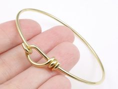 This beautifully crafted, adjustable wire bracelet works perfectly with TierraCast's YOU Collection of mini-pendants and charms.   Each bracelet is crafted of heavy, 12 gauge wire,  and is expertly finished, smoothed, and polished.   ★ This bright brass wire does not match gold components.Quantity: 1 Piece★ Optional - upgrade to a discounted bulk bag when you add to cart.Finish:  BRIGHT RAW BRASS - does not match goldSize:  2.4mm DiameterTierraCast Part #:   01-0301-09These bracelets are availab Handmade Hoop Bracelets, Perfect For Gifts, Handmade Adjustable Hoop Bracelets, Adjustable Hoop Bracelets As Gift, Adjustable Wire Bracelet, Blacksburg Va, Customized Jewelry, Natural Stone Jewelry, Mini Pendants, 12 Gauge