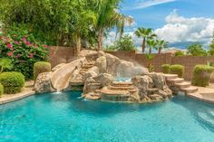 an outdoor pool with waterfall and rock steps