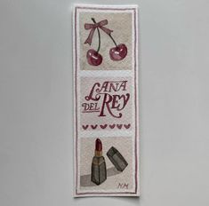 an embroidered banner with lipstick and cherries on it