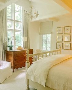 a bedroom with white furniture and large windows