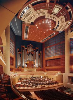 an empty concert hall with rows of seats and pipe organ in the center, overhead view