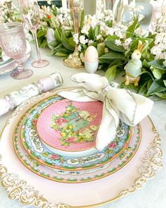 the table is set with pink and green plates