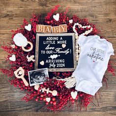 a baby announcement surrounded by red berries and other items