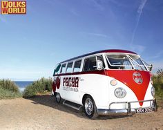 an old vw bus is parked on the side of the road by the ocean