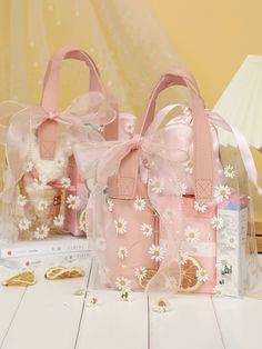 two pink purses sitting on top of a table next to some gold and white decorations