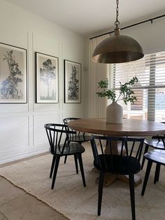 a dining room table with four chairs and a potted plant on top of it