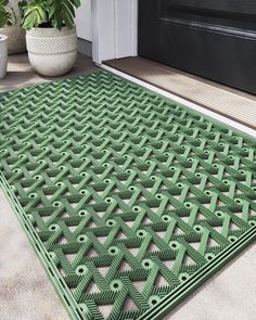 a green door mat sitting on top of a porch