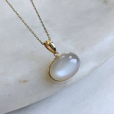 ITEM DESCRIPTION: >>The pendant is made from Solid 14K Yellow Gold. Gemstone used is absolutely natural and ethically sourced. >>Natural White Moonstones cabochon with bezel setting are studded on it with utmost precision. >>This is a minimalist design and is absolutely hassle-free and everyday jewelry. ✓ Gem: White Moonstone ✓ Gem size: 10x14 mm ✓ Gem weight: 6.98 carats ✓ Gold purity: 14K (58.33% approx.) ✓ Gold weight: 0.56 grams ✓ Gross weight: 1.96 grams The Gold purity is guaranteed and it Lapis Pendant, Handmade Jewelry Box, White Moonstone, Bezel Pendant, June Birthstone, Moonstone Jewelry, Moonstone Pendant, Unique Gemstones, June Birth Stone