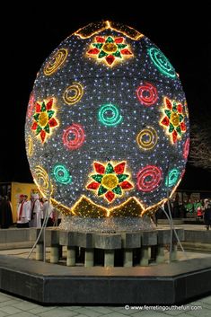 a large ball with lights on it in the middle of a plaza