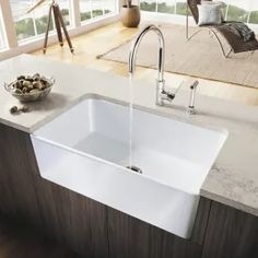 a white sink sitting under a faucet next to a counter top in a kitchen