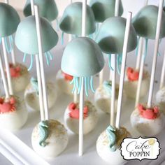 cakepops with blue and white frosting are on a tray