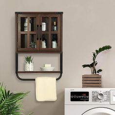 a washer and dryer sitting next to each other in front of a wall mounted cabinet