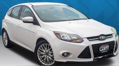 a white ford focus parked in front of a blue background