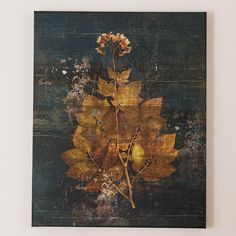 a painting hanging on the wall with leaves and flowers