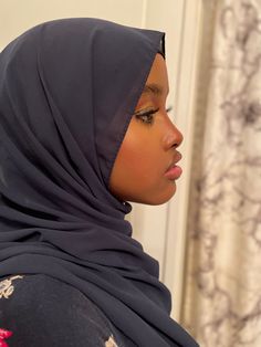 a woman wearing a black hijab looking off into the distance