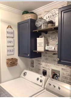 a washer and dryer in a laundry room next to cabinets with signs on them