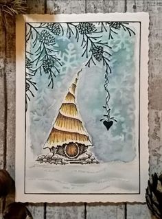 a card with an image of a house in the snow and pine cones around it