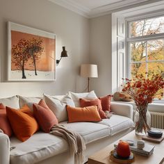 a living room filled with furniture and a painting on the wall above it's windows