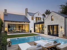 a house with a swimming pool in the middle of it and an outdoor lounge area