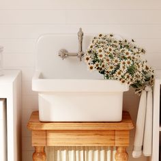 a white sink sitting on top of a wooden counter