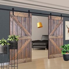 a living room filled with furniture and lots of wooden sliding barn door hardware on top of a hard wood floor