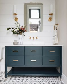 a bathroom with blue cabinets and white walls