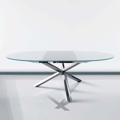 a glass table with metal legs on a white floor