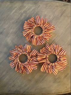 three red and white striped hair bows on a table top with holes in the middle