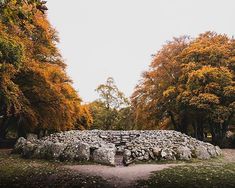 a stone structure surrounded by trees in the fall