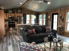 a living room filled with furniture and wooden walls