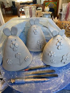 three clay mice sitting on top of a table next to paintbrushes and brushes