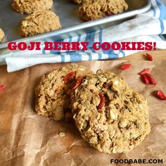 two oatmeal cookies sitting on top of a table next to a baking sheet