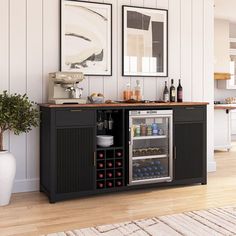 a kitchen with a wine cooler in the center and pictures on the wall above it