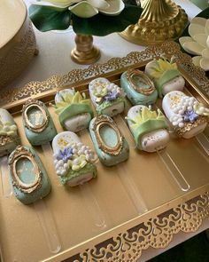 there are many decorated cookies on the trays that have flowers and pearls in them