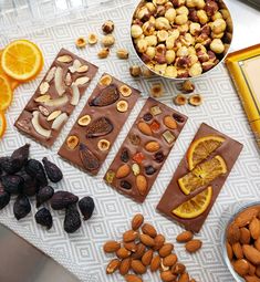 nuts, oranges, and chocolate are on the table with other food items around it