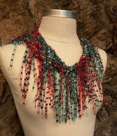 "Christmas scarf for women. Red and Green ladder yarn scarf necklace with sparkle for the holidays. Unique gift for women who has everything.  Dress up your holiday outfit with this beautiful fringe scarf with a nice bling. There is no teal in the green if your screen shows teal, it's gradient emerald green.  This is about 70\" long traditional scarf with well structured body.  Hand wash in lukewarm water with mild soap, don't rub or wring, squeeze of excess water and hang to dry.  Comes with nice organza satchel for traveling, storage or gift giving. Store the ribbon scarves flat in a drawer or hang them up.  Handmade in United States of America.  Visit my store front at  www.Etsy.com/shop/thinkerbella for more color and design options.  Free shipping on orders over $35. Just add all the Handmade Red Scarves As Gift, Green Scarves For Winter Gifts, Handmade Red Scarf As A Gift, Red Bohemian Scarf As Gift, Green Winter Scarf For Gift, Red Scarves For Gifts, Green Winter Scarves For Gifts, Handmade Red Scarf For Gift, Red Winter Scarves Perfect For Gifts