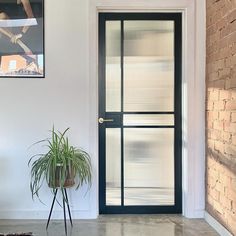 a room with a brick wall and black door